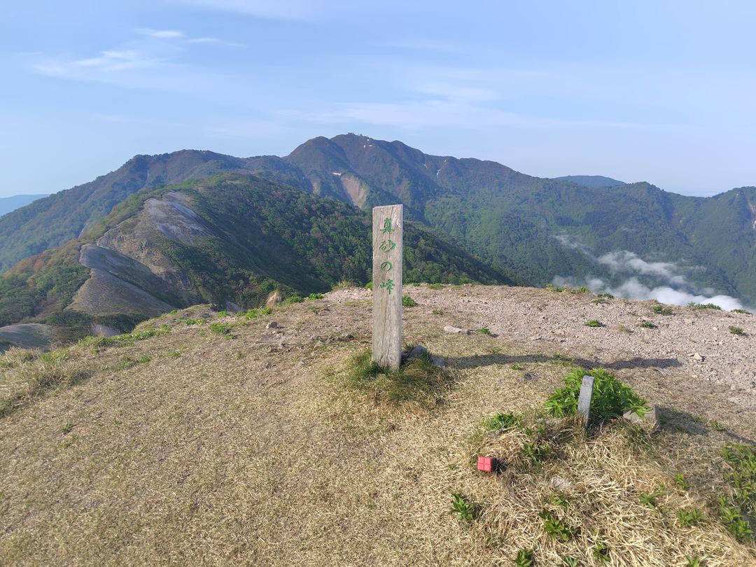 真砂の峰山頂の標柱と金北山方面の眺望