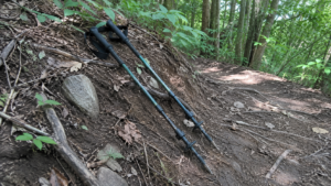 登山道に置かれた使い込まれたI型トレッキングポール2本