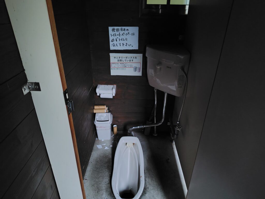 鳥倉登山口駐車場のトイレ個室内部。電灯のない和式の水洗トイレ