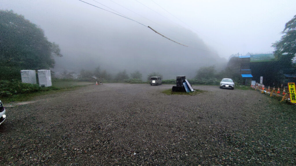 柏原新道登山口駐車場の全景。約30台分の未舗装スペース
