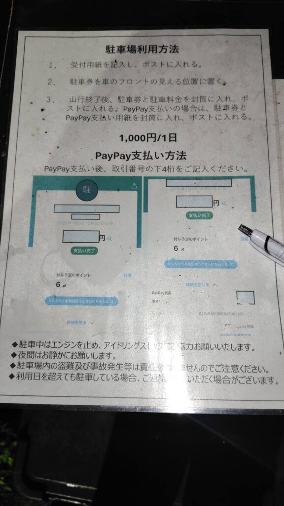 徳本峠登山口駐車場の受付。受付用紙と封筒、支払い方法の説明が玄関前に置かれている