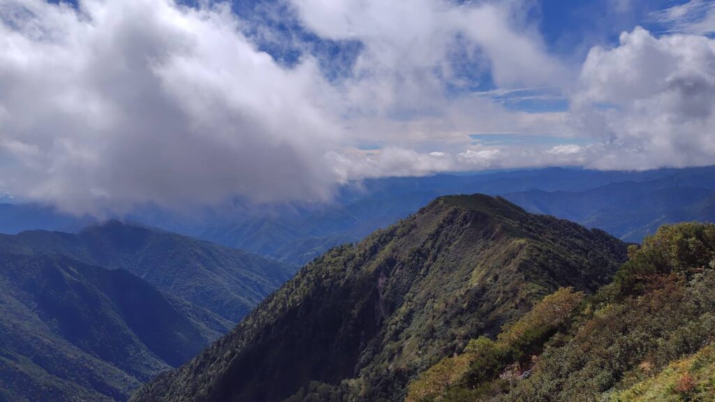 霞沢岳山頂付近からの展望。雲の切れ間に稜線が連なる