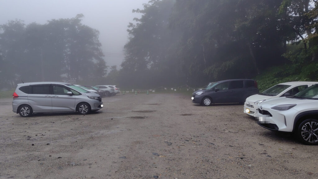 扇沢の市営無料駐車場。砂利敷きで登山者の前泊に使われる