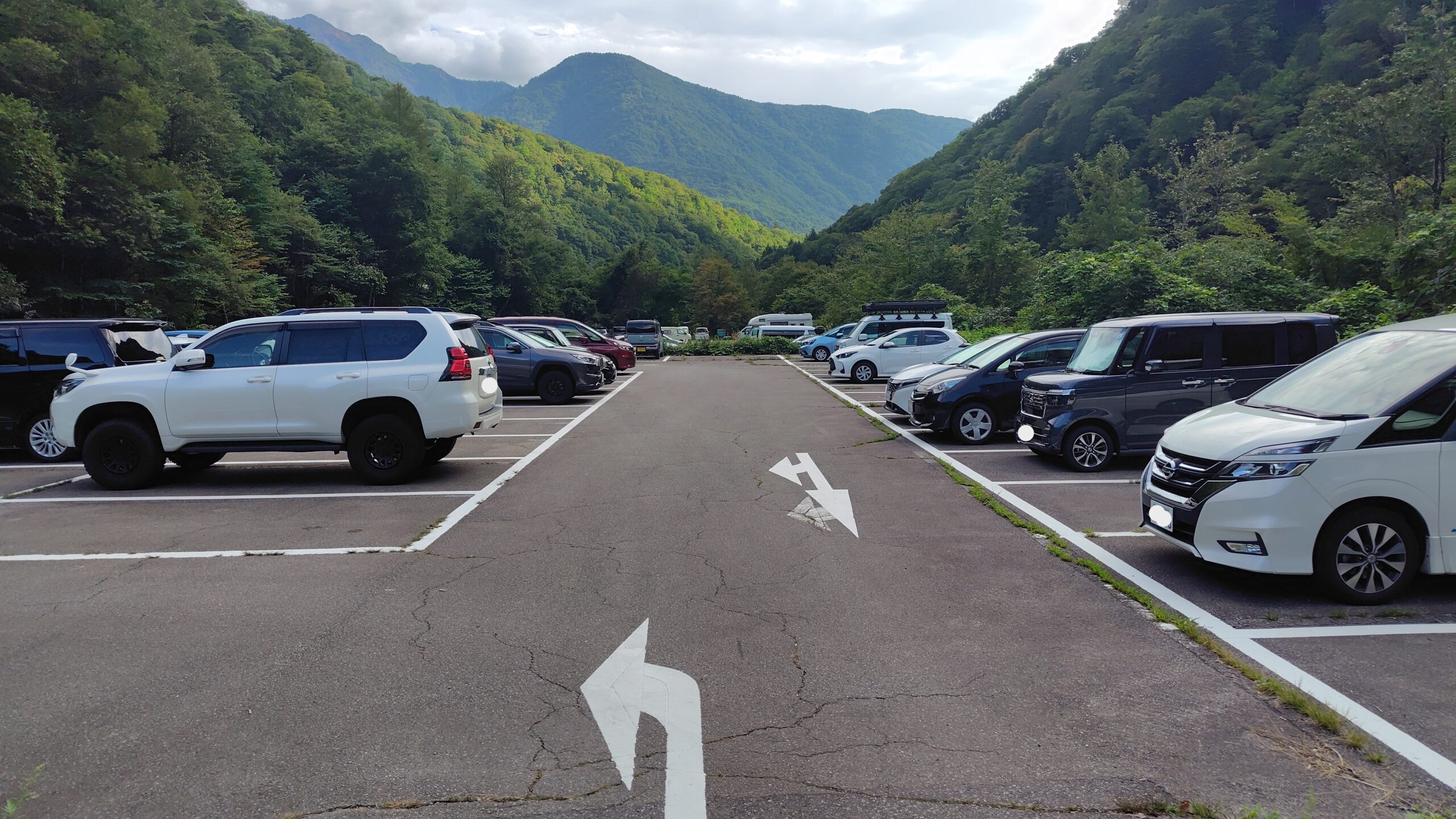 新穂高の無料駐車場の全景。舗装と白線が引かれ、区画が整理されている