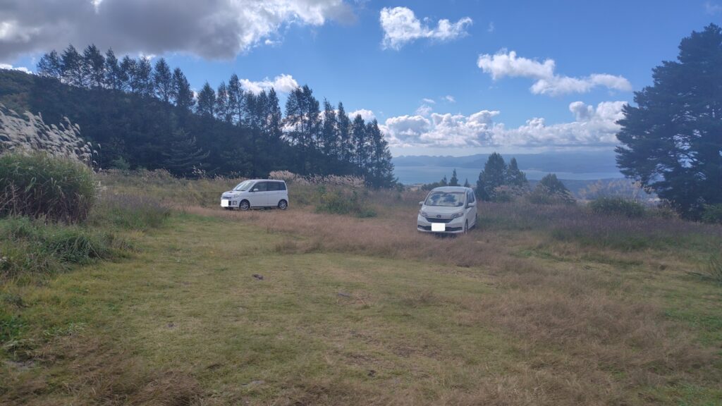 翁島登山口の駐車スペース。奥に猪苗代湖が見える