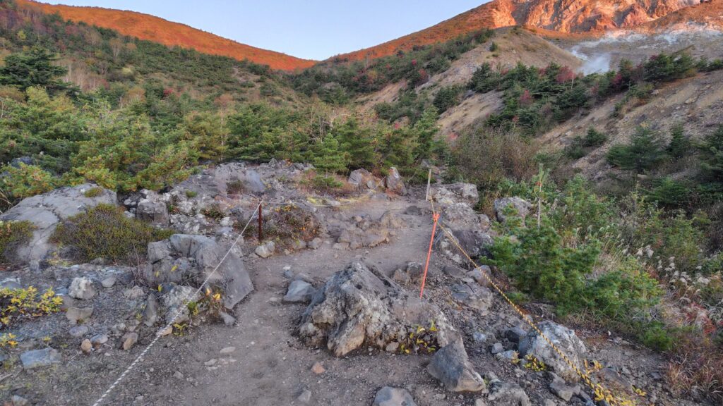 ロープで区切られた歩きやすい登山道と噴気の上がる斜面